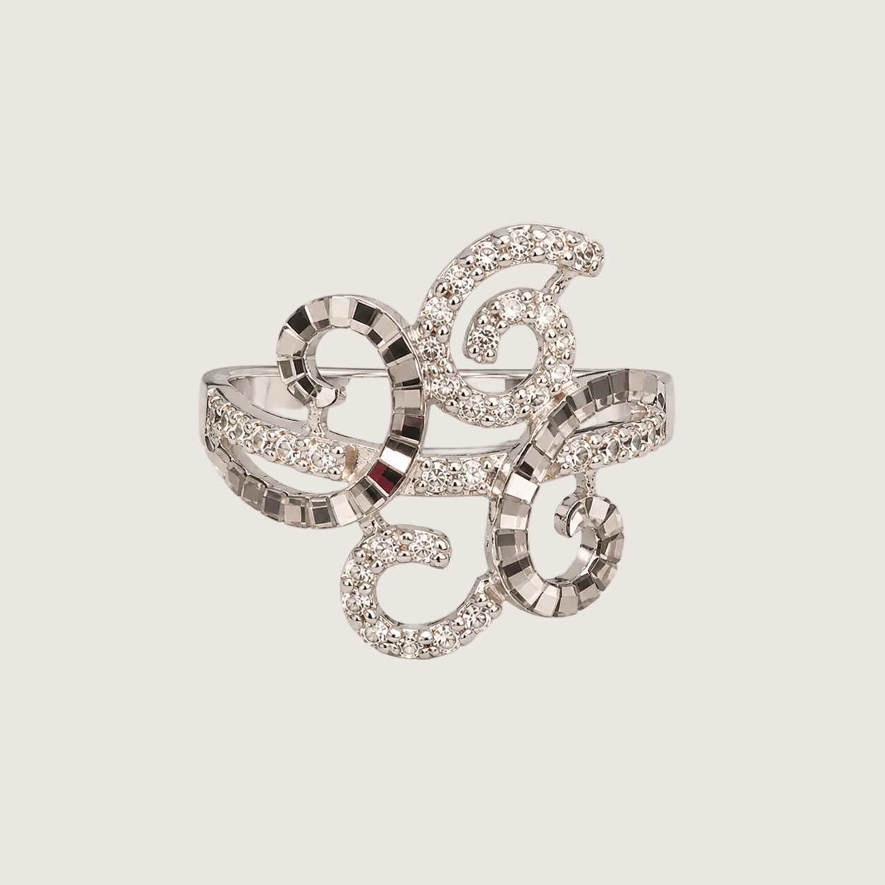 Silver ring with intricate design on a light beige background