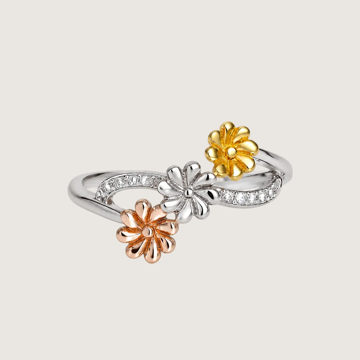 Three-flower ring with gold, silver, and rose gold colors on a light beige background