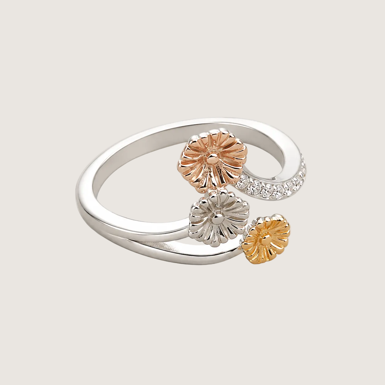 Three-layered ring with rose gold, silver, and yellow gold elements on a light background