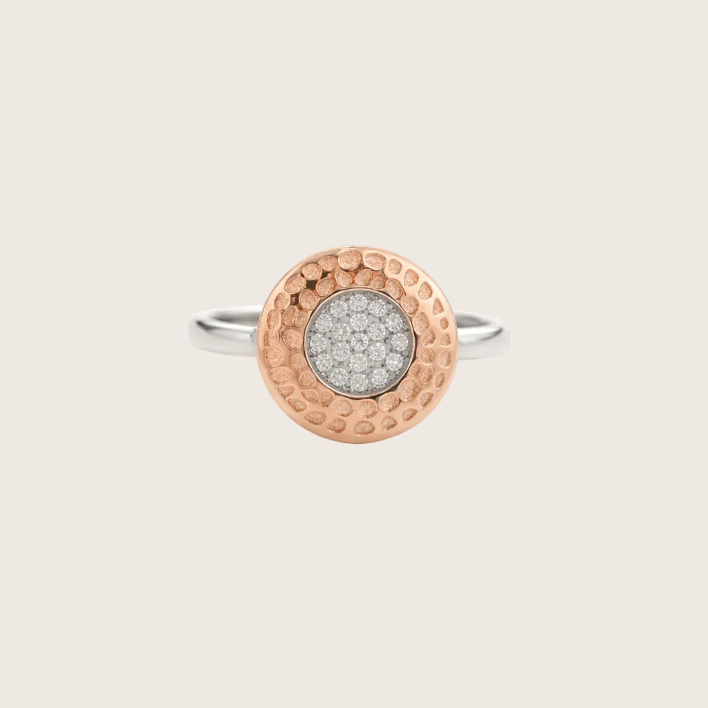 Two-tone ring with textured band and diamond-studded center on a light gray background