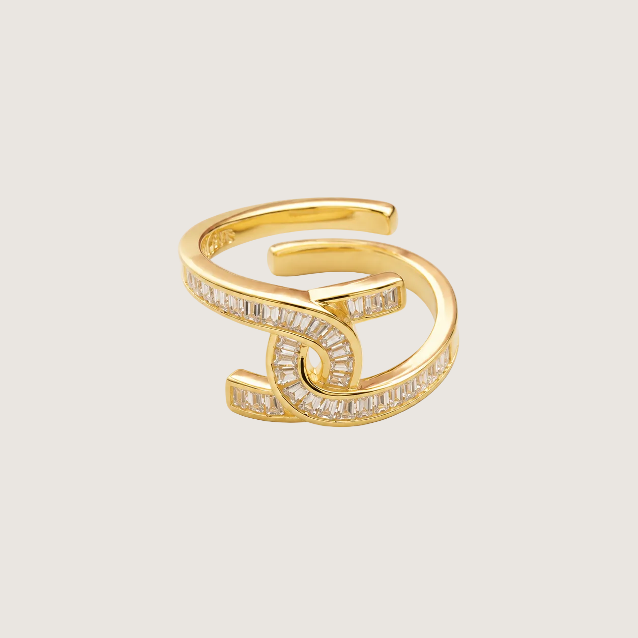 Gold ring with diamond accents on a light beige background
