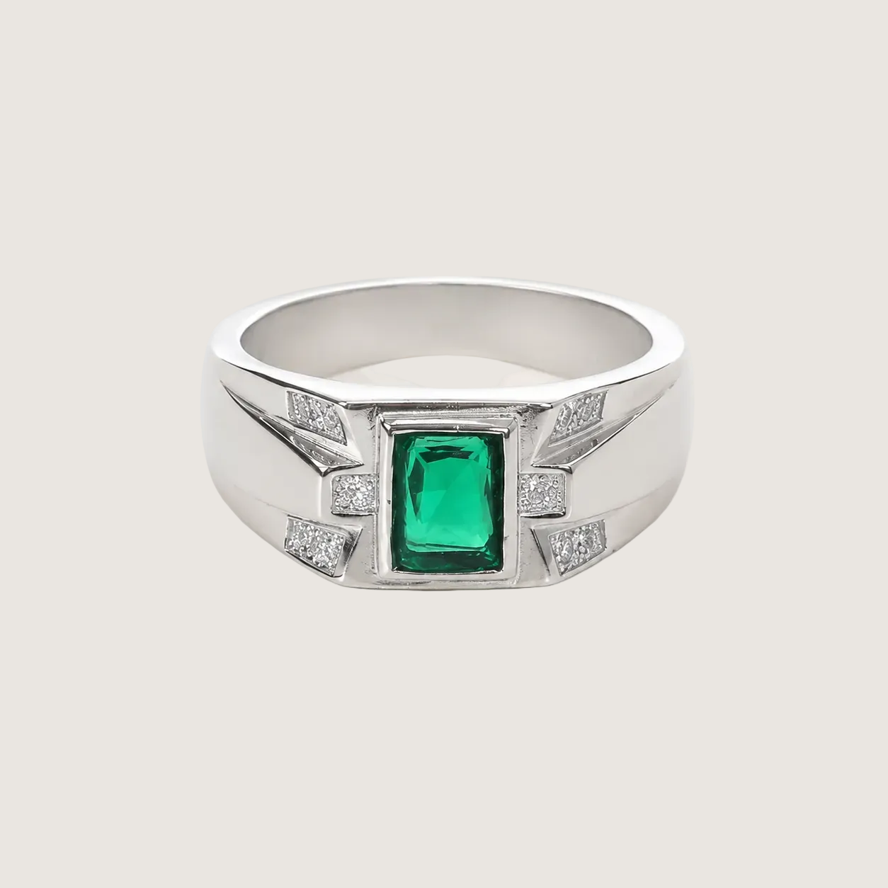 Silver ring with a green gemstone and diamond accents on a light gray background