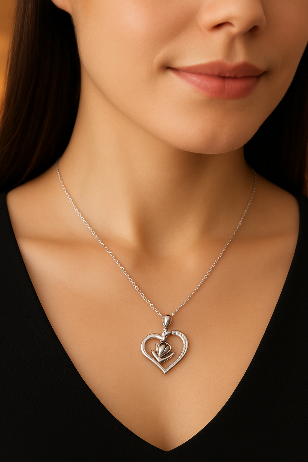 Silver heart-shaped necklace worn by a person against a neutral background