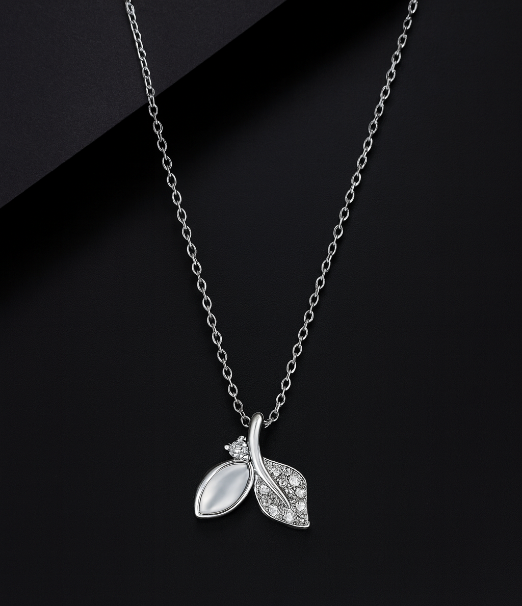 Silver necklace with a leaf-shaped pendant on a black background