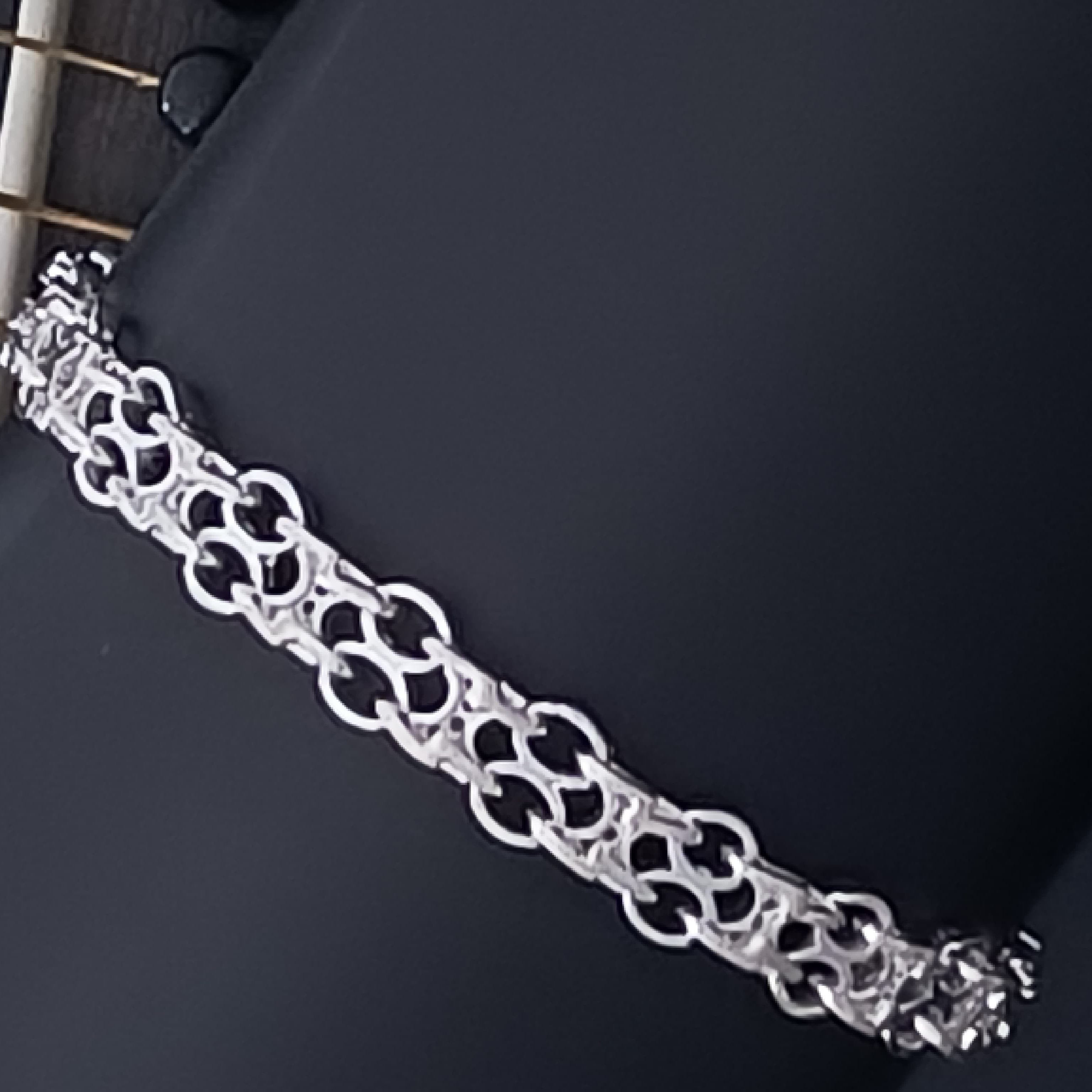 Silver chain bracelet on a dark surface