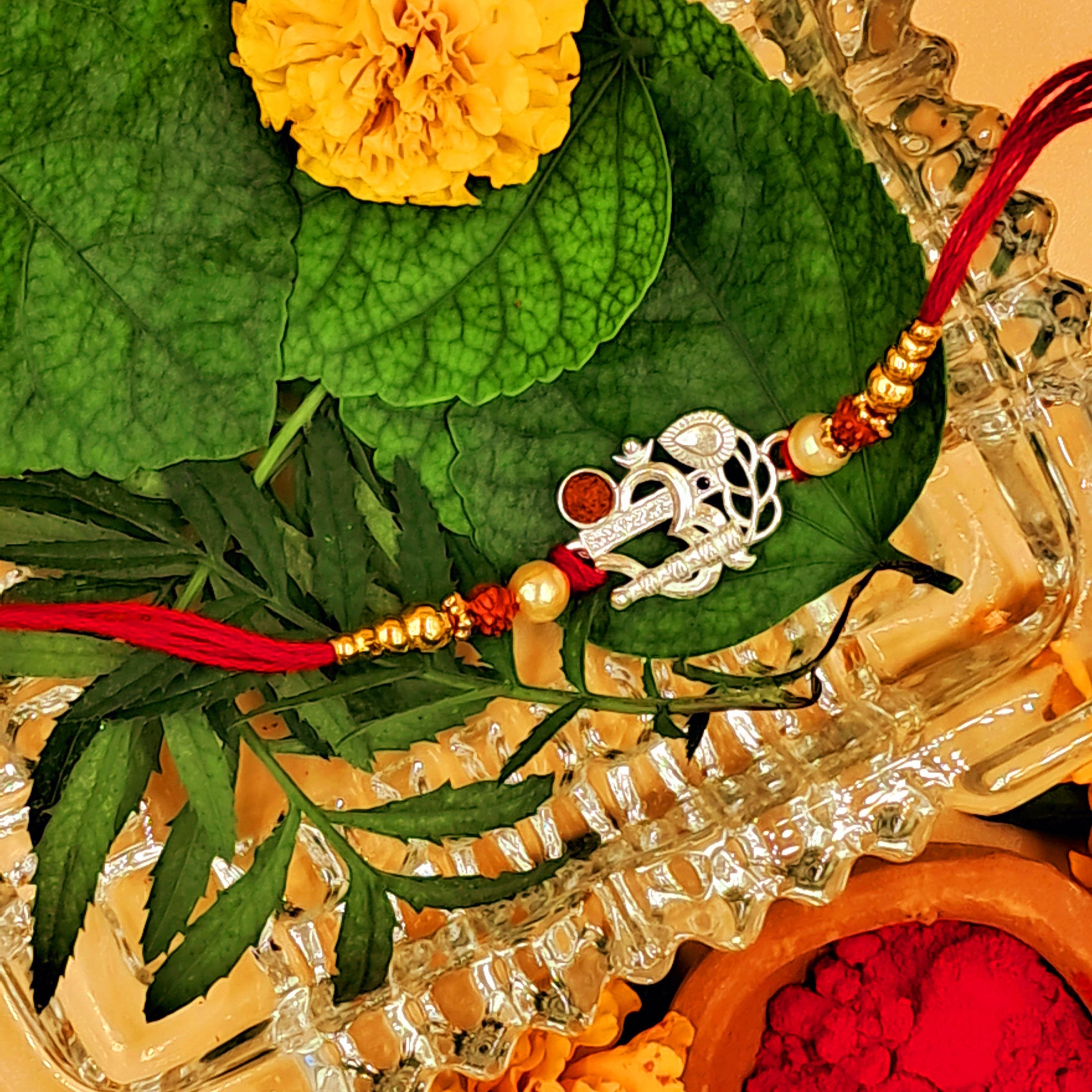 Rakhi with flowers and leaves on a decorative background