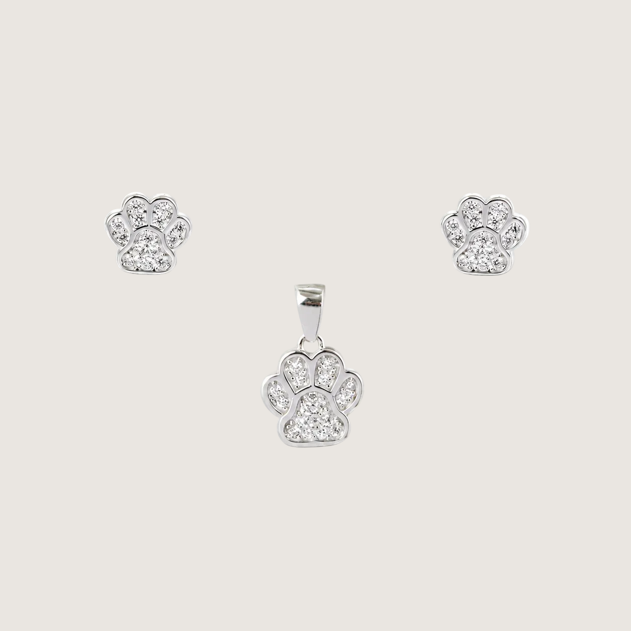Silver paw-shaped pendant and earrings on a beige background