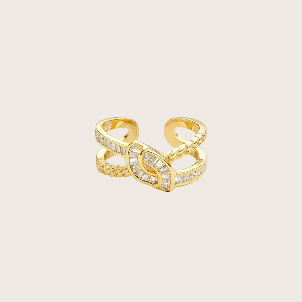 Gold ring with intricate design on a light gray background