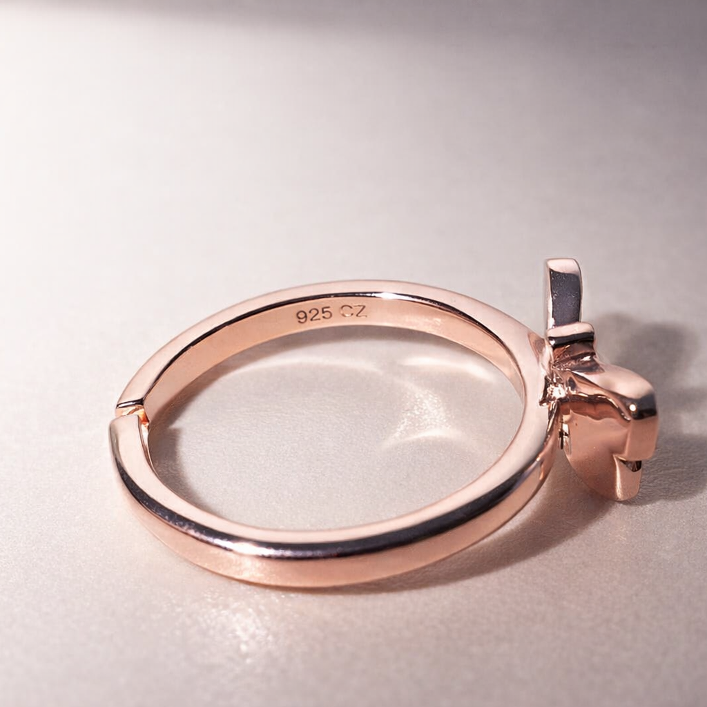 Rose gold ring with a magnifying glass on a light gray background