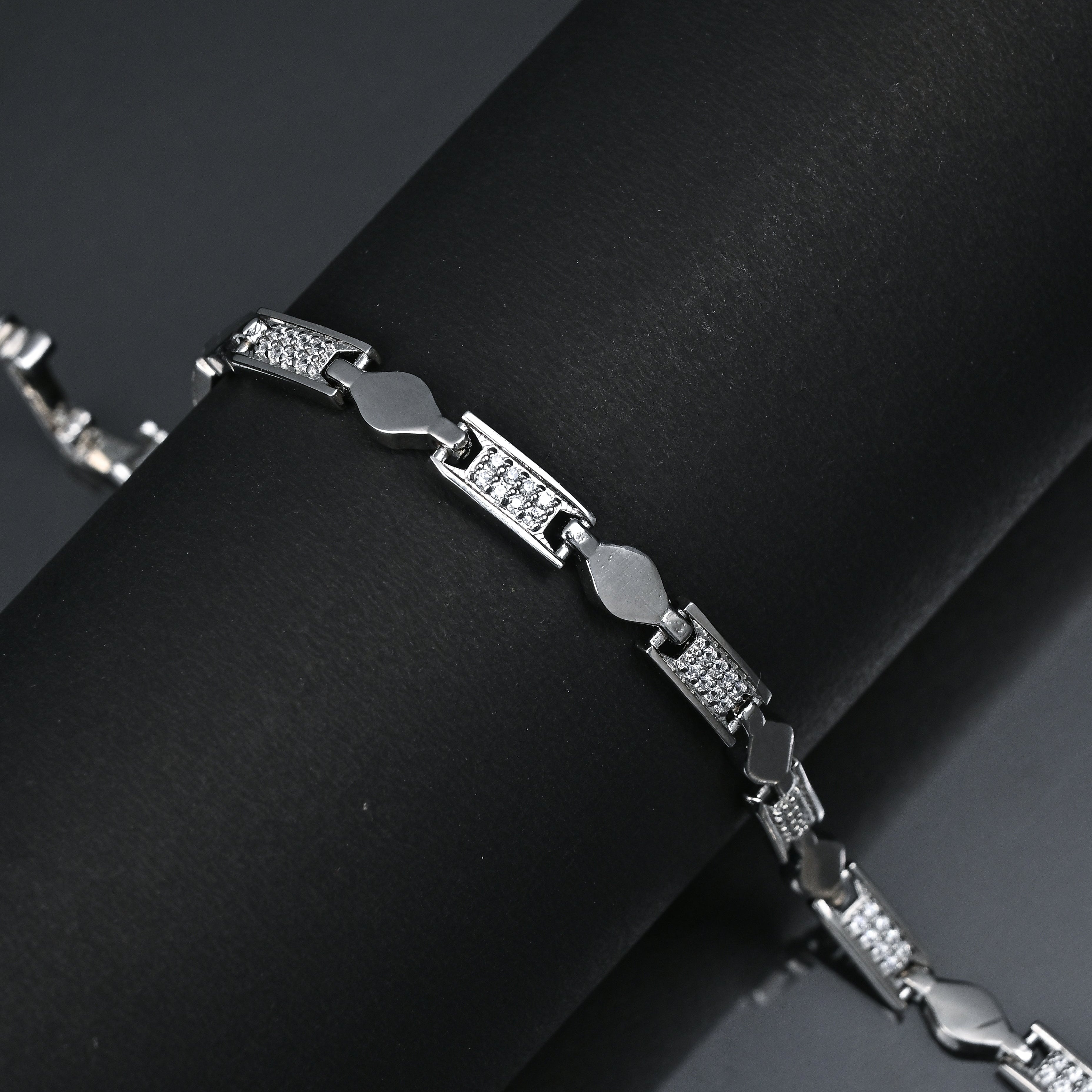Silver bracelet on a black background with 'TRISHNHA' branding.