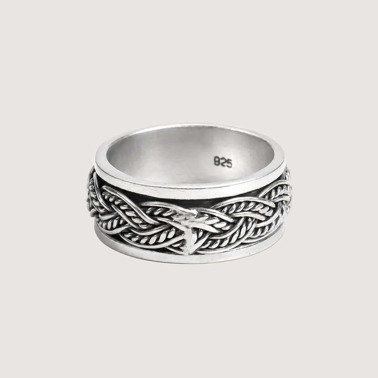 Silver ring with braided design on a light beige background