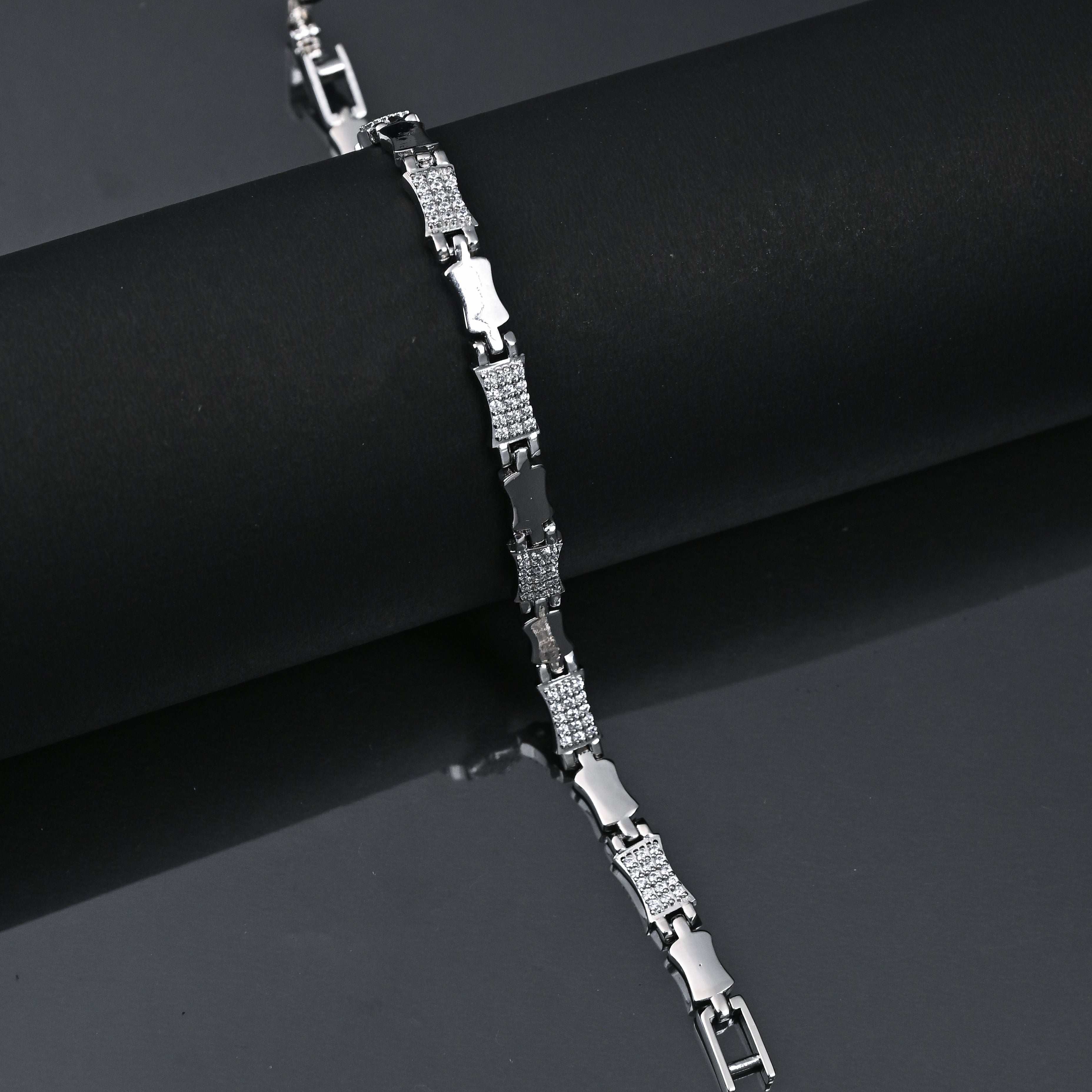 Silver bracelet on a dark background with 'TRISHNHA' branding.