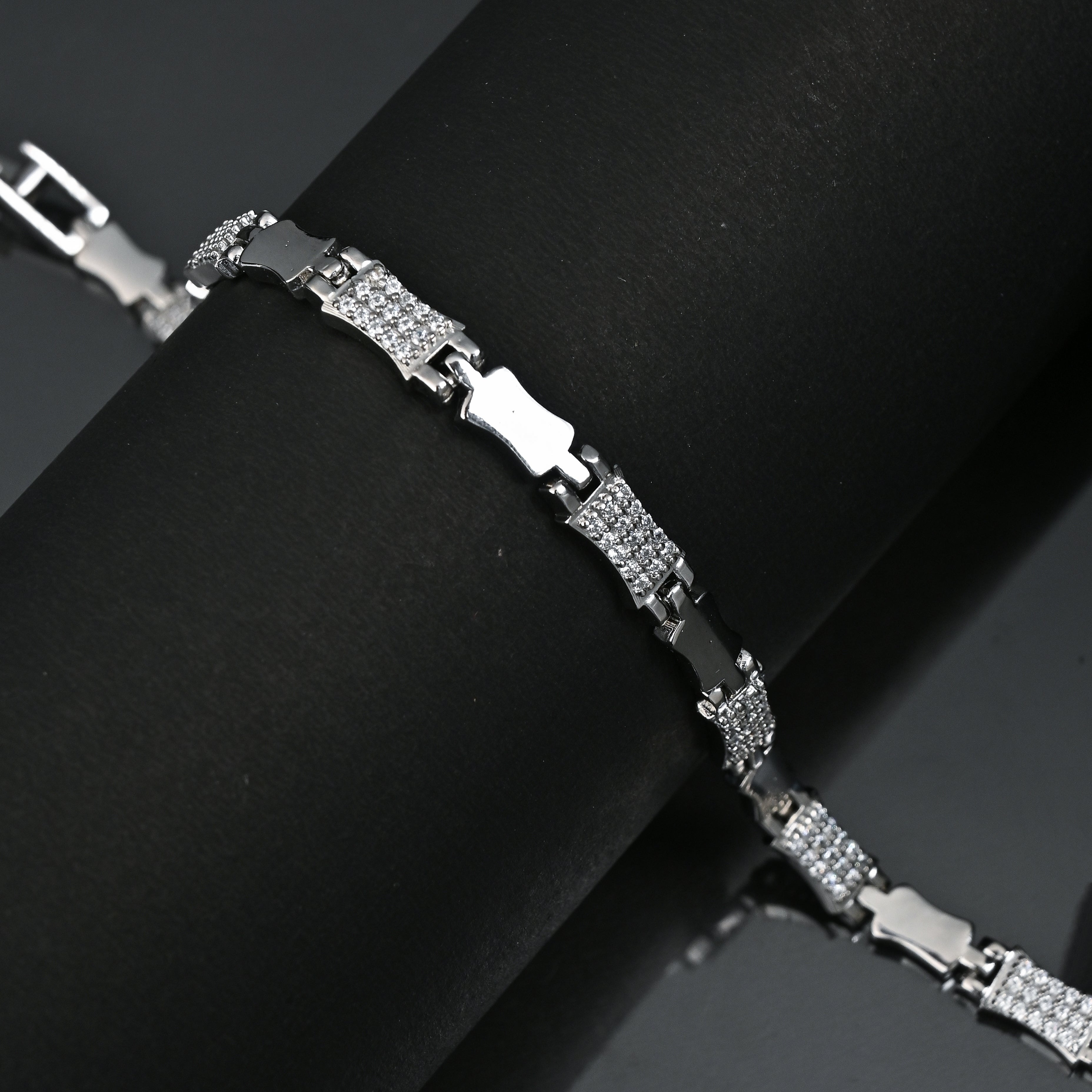 Silver bracelet on a black surface with 'TRISHNHA' branding.