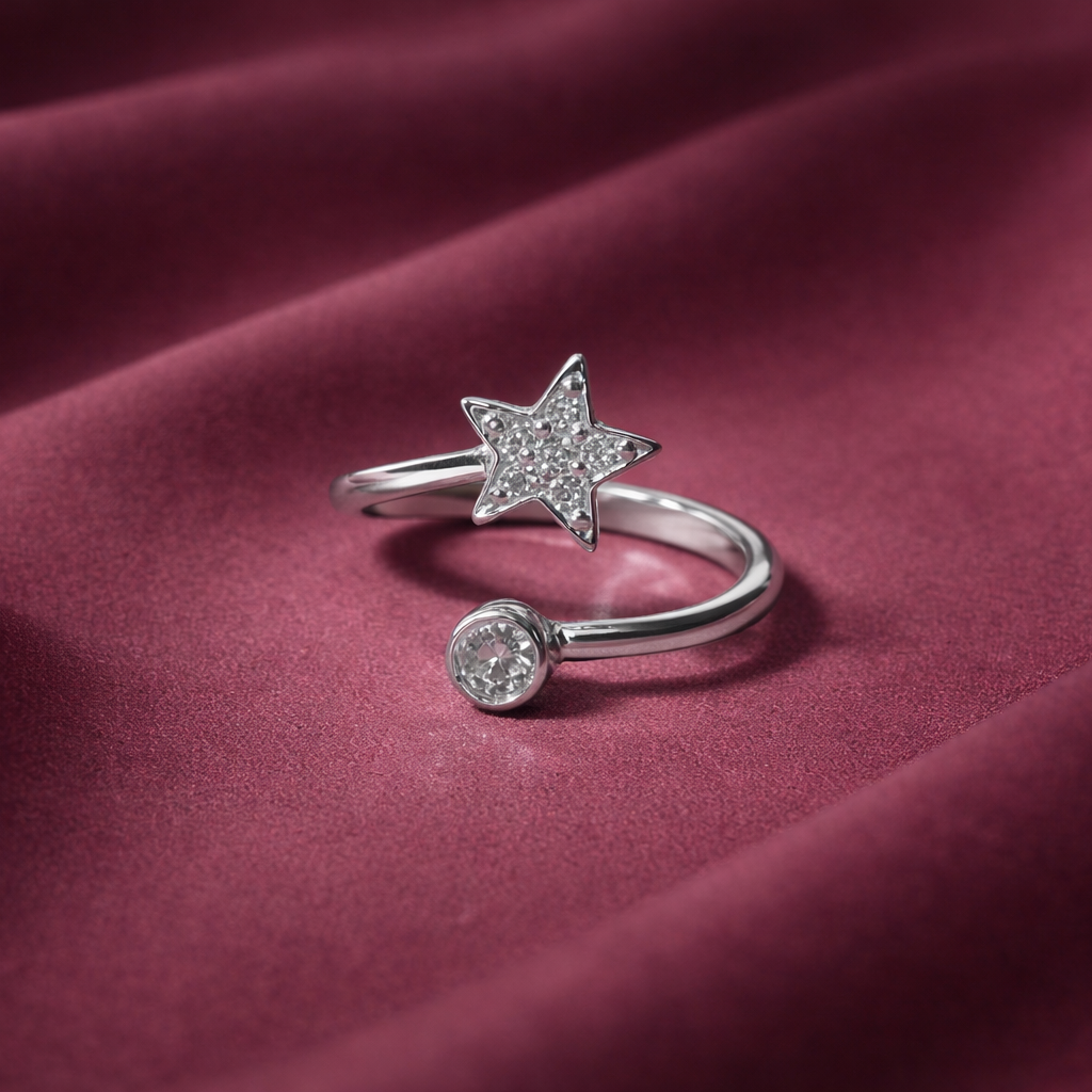 Silver open ring with star and round gemstone on a burgundy fabric background