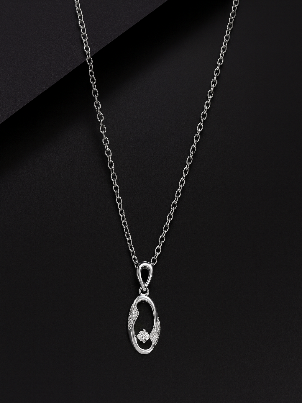Silver necklace with a pendant on a black background