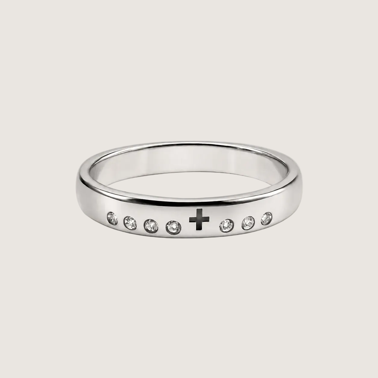 Silver ring with a cross and small stones on a light beige background