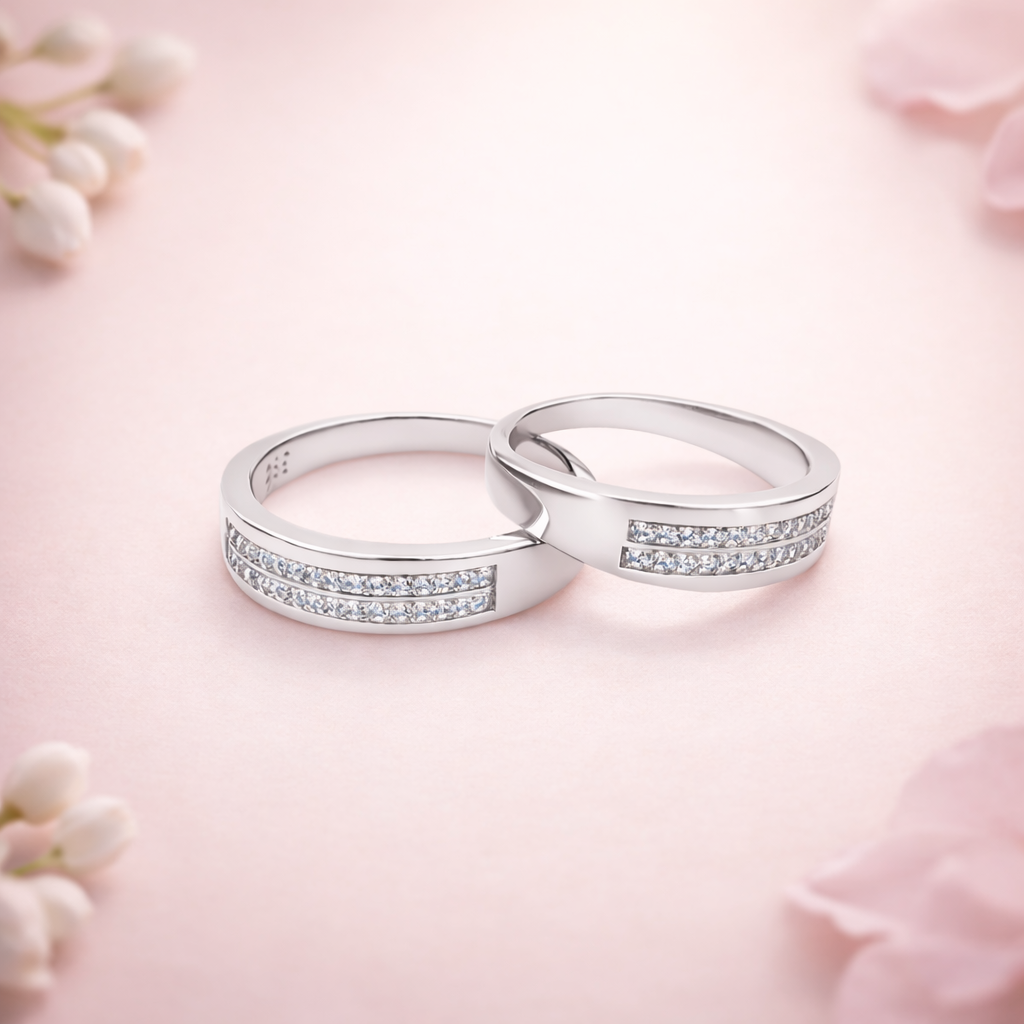 Two silver rings with small diamonds on a pink floral background