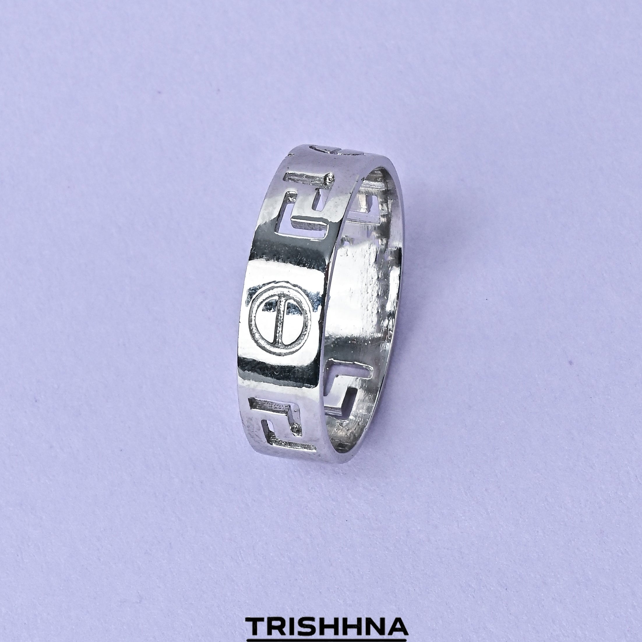 Silver ring with engraved design on a light purple background, featuring the brand 'Trishna'.