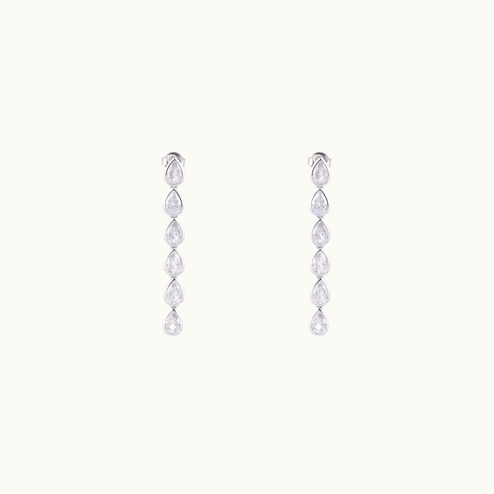 Pair of silver drop earrings with clear gemstones on a white background