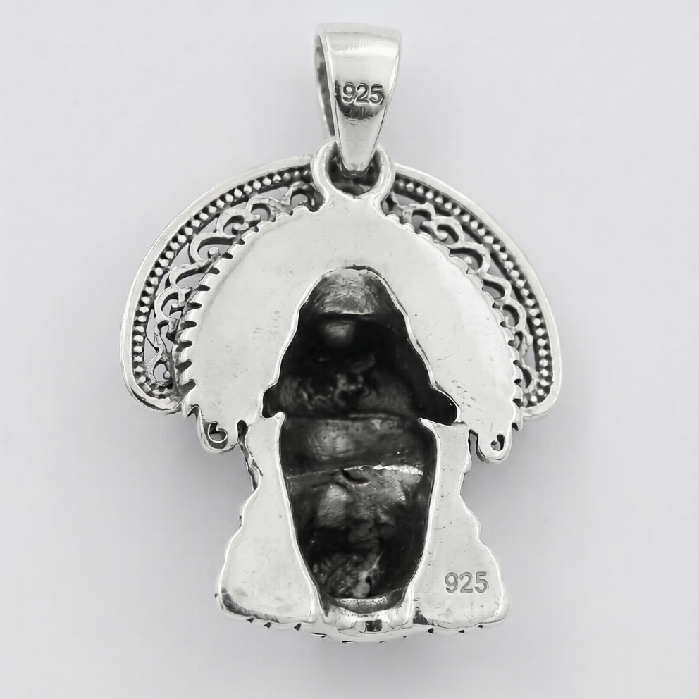 Silver pendant with a face design on a white background