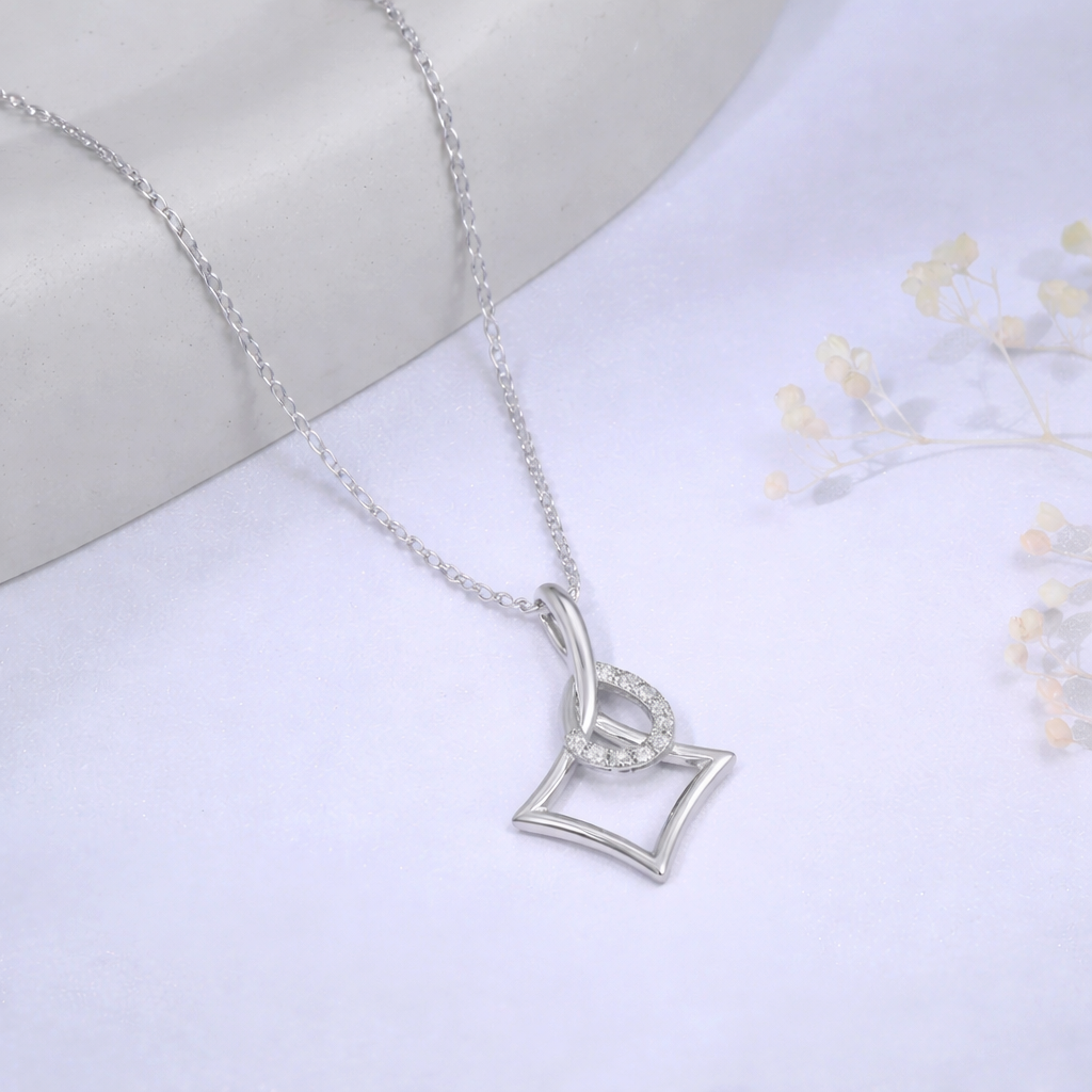 Silver necklace with a heart-shaped pendant on a white fabric background