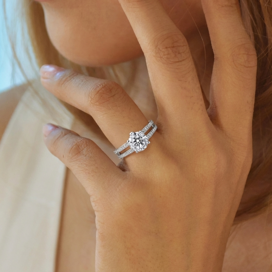 Close-up of a hand wearing a diamond ring with a blurred background